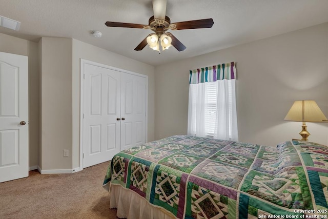 carpeted bedroom featuring a ceiling fan, a closet, baseboards, and visible vents