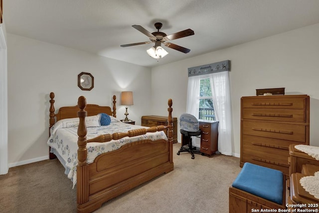 bedroom with light carpet, baseboards, and a ceiling fan