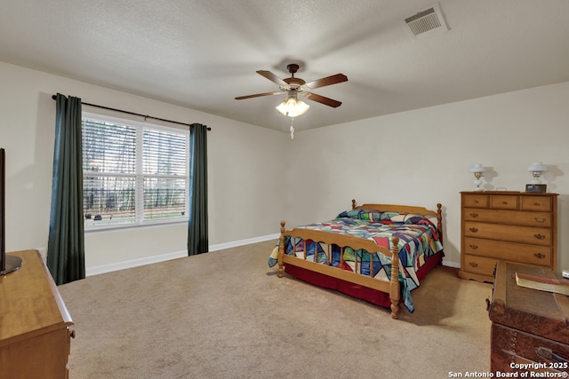 carpeted bedroom featuring baseboards, ceiling fan, and visible vents