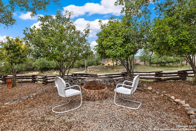 view of yard featuring an outdoor fire pit and fence
