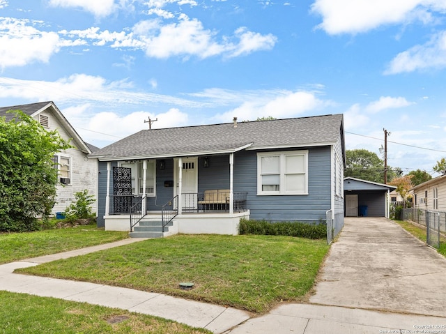 view of front of property featuring a porch, roof with shingles, fence, concrete driveway, and a front yard