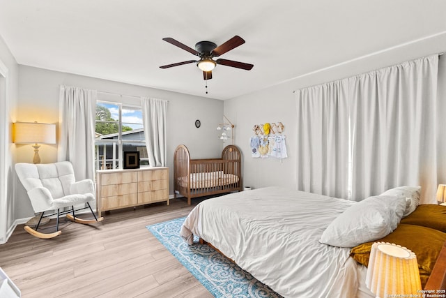 bedroom with a ceiling fan and light wood-style floors