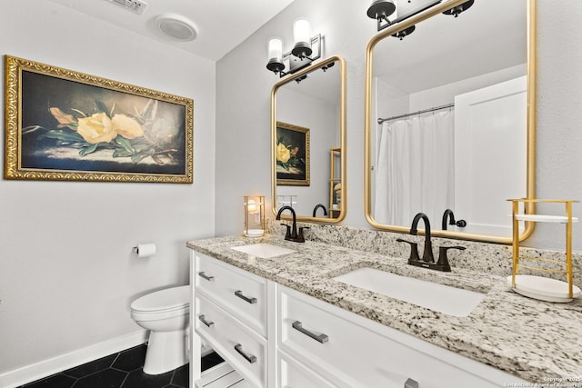 bathroom with toilet, tile patterned flooring, baseboards, and a sink