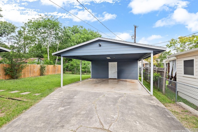 view of front of property featuring a front lawn, driveway, fence, and a detached carport