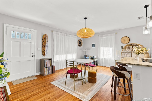 dining room featuring light wood-type flooring and visible vents