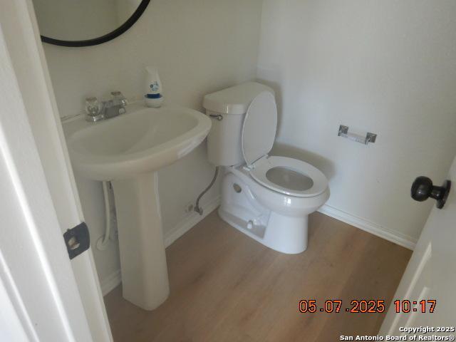 9922 Dull Knife Way, San Antonio, TX 78239 - half bath with baseboards, wood finished floors, and toilet