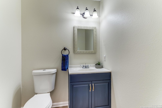 half bath featuring vanity and toilet