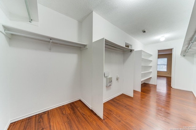 walk in closet featuring visible vents and wood finished floors