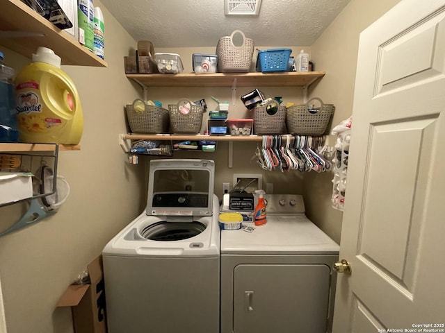 laundry room featuring washer and clothes dryer, laundry area, a textured ceiling, and visible vents