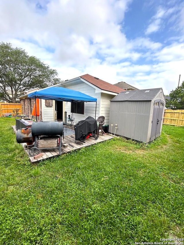 back of property with a storage unit, fence, a yard, and an outdoor structure