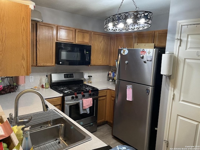 kitchen with light countertops, stainless steel appliances, brown cabinets, and a sink