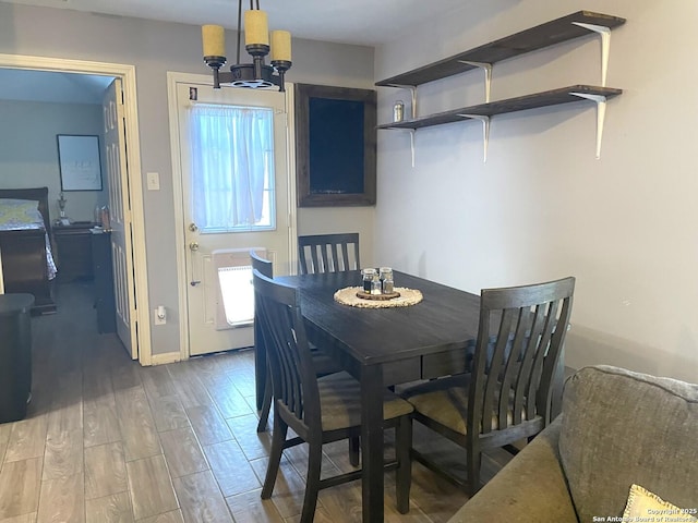 dining area featuring baseboards, an inviting chandelier, and wood finished floors