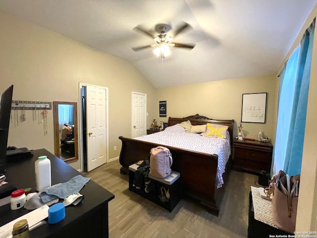bedroom with lofted ceiling, a ceiling fan, and wood finished floors