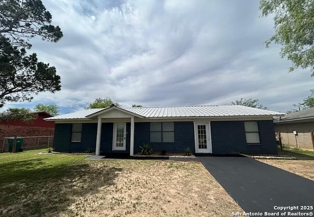 1107 Willow, Jourdanton, TX 78026 - ranch-style house featuring metal roof, a front lawn, and fence
