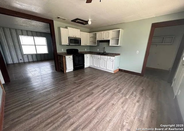 1107 Willow, Jourdanton, TX 78026 - kitchen featuring stainless steel microwave, a sink, black gas range oven, visible vents, and dark countertops