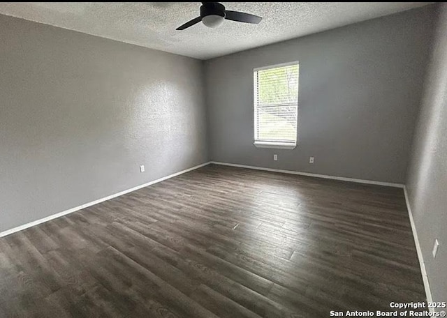 1107 Willow, Jourdanton, TX 78026 - spare room with a ceiling fan, dark wood-style flooring, baseboards, and a textured ceiling
