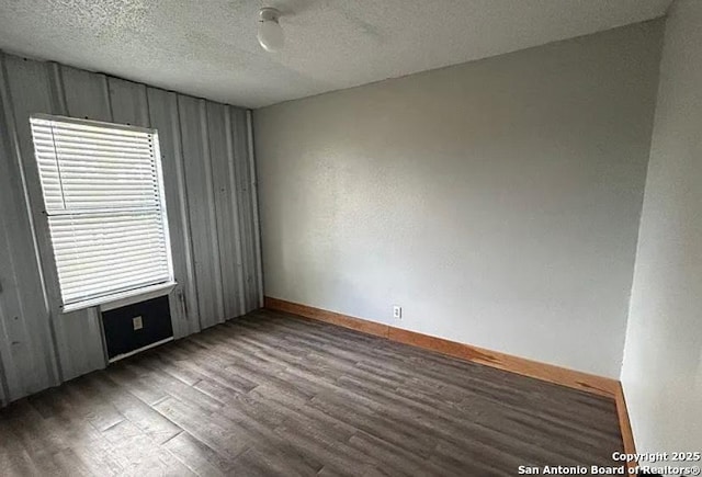 1107 Willow, Jourdanton, TX 78026 - empty room featuring baseboards, a textured ceiling, and wood finished floors