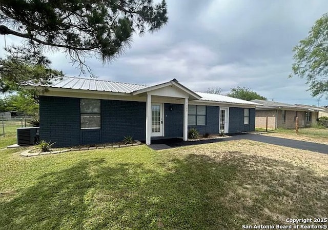1107 Willow, Jourdanton, TX 78026 - ranch-style house featuring brick siding, metal roof, a front yard, and central AC