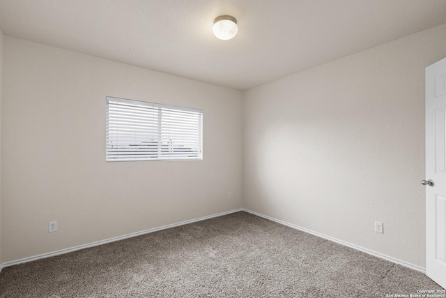 carpeted empty room with baseboards