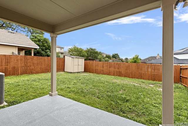 view of yard featuring a fenced backyard, a patio area, a storage unit, and an outdoor structure
