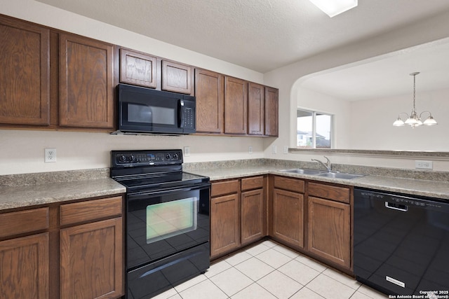kitchen featuring a sink, decorative light fixtures, black appliances, a chandelier, and light tile patterned floors