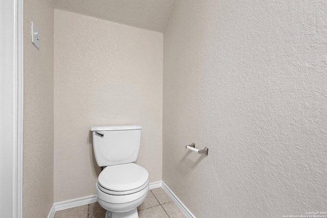 bathroom with toilet, baseboards, and tile patterned floors