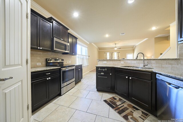242 Posey Pass, New Braunfels, TX 78132 - kitchen with a sink, crown molding, backsplash, and appliances with stainless steel finishes