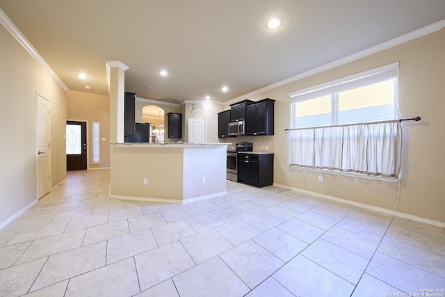 242 Posey Pass, New Braunfels, TX 78132 - kitchen featuring a wealth of natural light, ornamental molding, dark cabinets, and appliances with stainless steel finishes