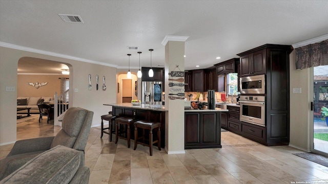6139 Mackenzie, San Antonio, TX 78247 - kitchen featuring appliances with stainless steel finishes, arched walkways, dark brown cabinets, light countertops, and crown molding