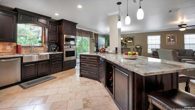 6139 Mackenzie, San Antonio, TX 78247 - kitchen featuring appliances with stainless steel finishes, backsplash, dark brown cabinets, open floor plan, and a sink