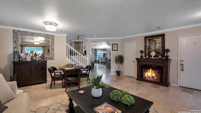 6139 Mackenzie, San Antonio, TX 78247 - living area with arched walkways, a glass covered fireplace, stairway, crown molding, and light tile patterned floors
