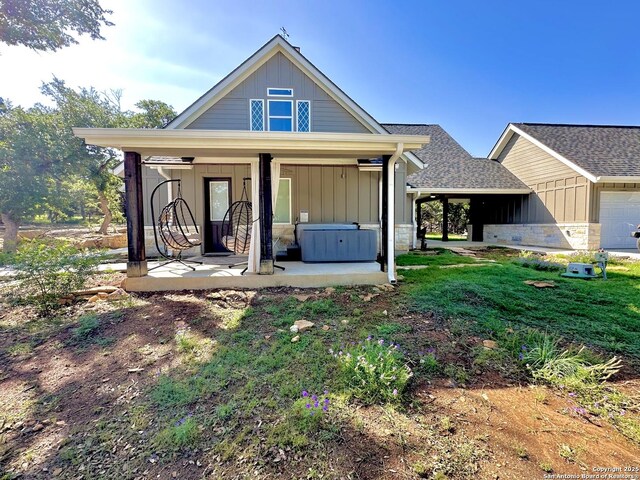 181 Crazy Horse, Canyon Lake, TX 78133 - rear view of house with board and batten siding, roof with shingles, a garage, and a patio area