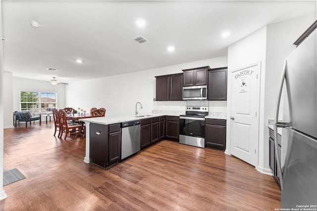 15102 Jetfire, Von Ormy, TX 78073 - kitchen with a peninsula, visible vents, dark wood-style flooring, ceiling fan, and appliances with stainless steel finishes