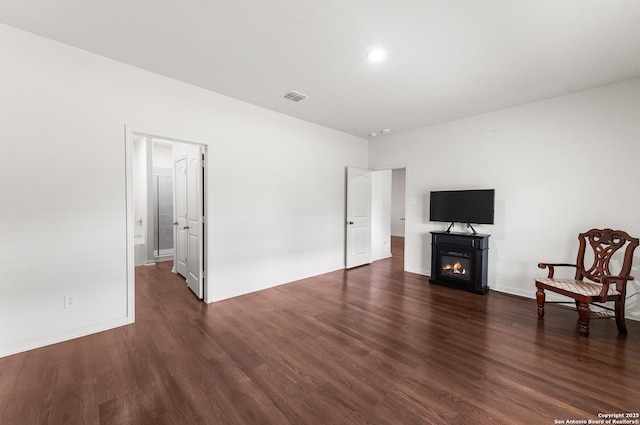 15102 Jetfire, Von Ormy, TX 78073 - unfurnished living room featuring a glass covered fireplace, baseboards, visible vents, and wood finished floors