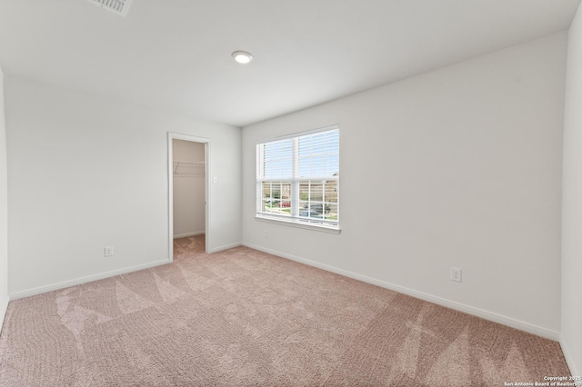 15102 Jetfire, Von Ormy, TX 78073 - unfurnished bedroom featuring baseboards, light carpet, a closet, and a walk in closet