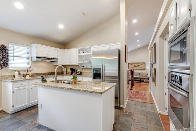 kitchen featuring a sink, open shelves, stone tile flooring, appliances with stainless steel finishes, and lofted ceiling