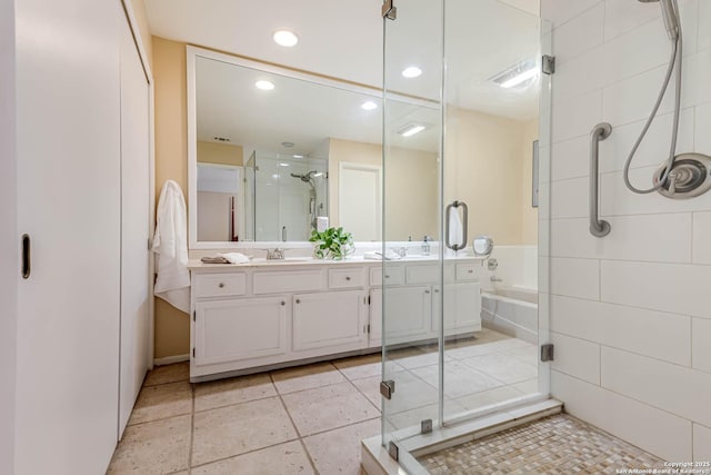 bathroom featuring tile patterned floors, a stall shower, recessed lighting, double vanity, and a bath