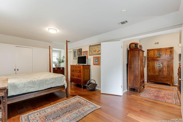 bedroom featuring light wood-style floors and visible vents