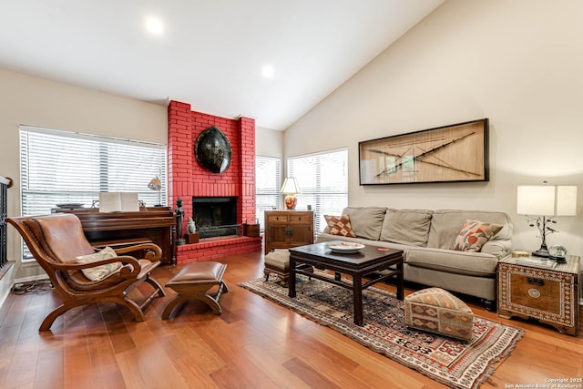 living room featuring recessed lighting, wood finished floors, a fireplace, and high vaulted ceiling