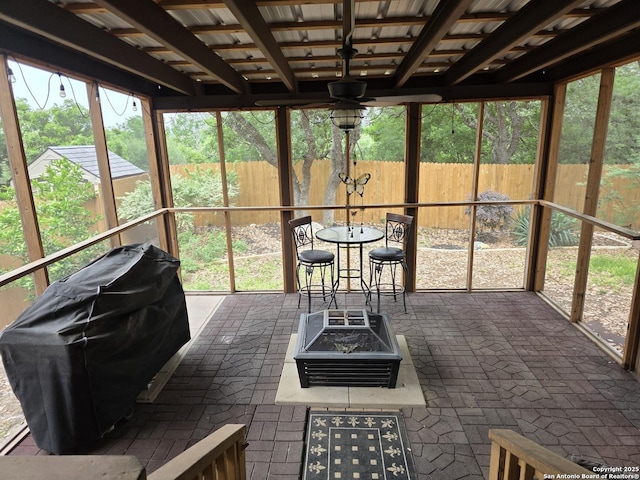 sunroom / solarium featuring an outdoor fire pit and a ceiling fan