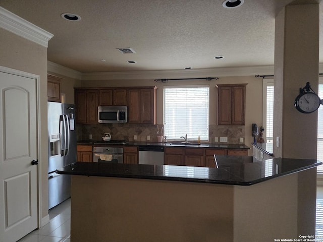 kitchen featuring dark countertops, stainless steel appliances, and ornamental molding
