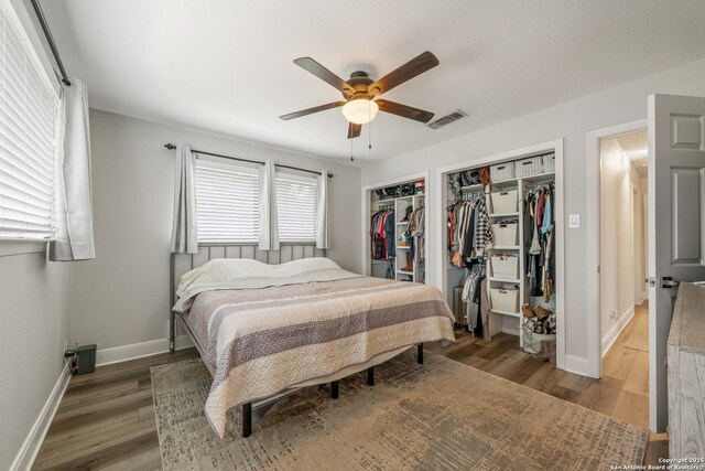 1397 Desert Gold, Boerne, TX 78006 - bedroom featuring wood finished floors, baseboards, ceiling fan, and multiple closets