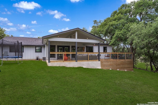 1397 Desert Gold, Boerne, TX 78006 - back of property featuring a trampoline, board and batten siding, a lawn, and a shingled roof