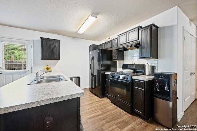 4902 Everett Loop, Converse, TX 78109 - kitchen featuring under cabinet range hood, a sink, black appliances, light wood-style floors, and light countertops