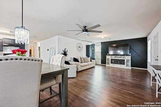 4902 Everett Loop, Converse, TX 78109 - living room with an accent wall, ceiling fan with notable chandelier, and dark wood finished floors