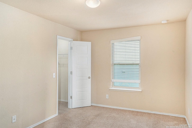 1819 Gray Fox Crk, San Antonio, TX 78245 - unfurnished bedroom with light colored carpet, a spacious closet, baseboards, and multiple windows