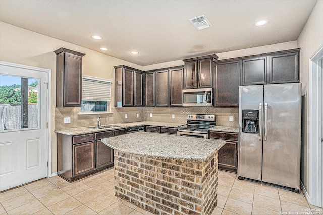 1819 Gray Fox Crk, San Antonio, TX 78245 - kitchen with light tile patterned floors, stainless steel appliances, a sink, and dark brown cabinets
