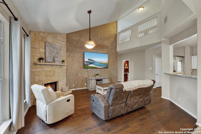 living area featuring baseboards, dark wood finished floors, high vaulted ceiling, and visible vents