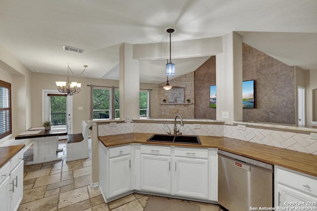 kitchen with butcher block countertops, a sink, visible vents, backsplash, and stainless steel dishwasher
