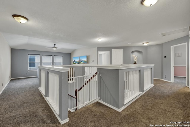 hallway with baseboards, carpet flooring, an upstairs landing, and a textured ceiling